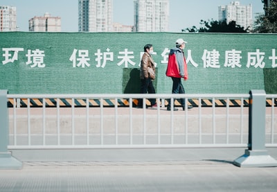 两个女人白天站在灰色的水泥路上